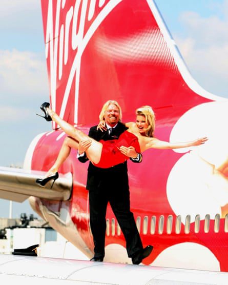 Richard Branson niesie Kate Moss wzdłuż skrzydła samolotu.